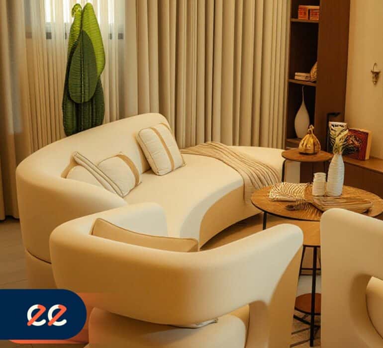 تصريح الصورة: غرفة معيشة أنيقة مع أريكة بيضاء وكراسي مريحة وديكور حديث يبرز مشاريع ايلفينز في تصاميم داخلية مميزة.