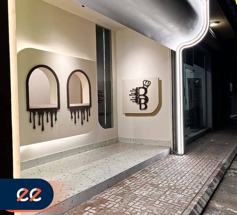 تصميم داخلي حديث لمقهى أو مطعم مع لافتة جذابة وشعار أنيق لعلامة تجارية، مع إضاءة LED مميزة ومساحة للمشروبات أو الطعام، يعكس الجودة والابتكار في مشاريع ايلفينز.