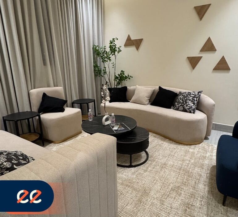 تصميم داخلي أنيق لغرفة معيشة حديثة بمشاريع إيلفينز، مع أرائك مريحة، وسجاد أنيق، وديكور مدروس يعكس الفخامة والراحة، مثالية للمشاريع السكنية والتجارية.