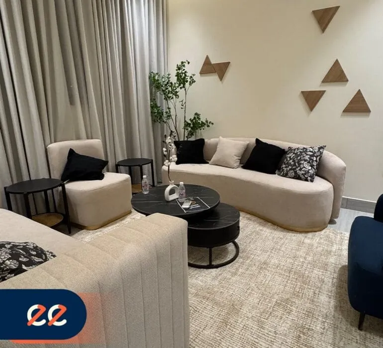 تصميم داخلي أنيق لغرفة معيشة حديثة بمشاريع إيلفينز، مع أرائك مريحة، وسجاد أنيق، وديكور مدروس يعكس الفخامة والراحة، مثالية للمشاريع السكنية والتجارية.