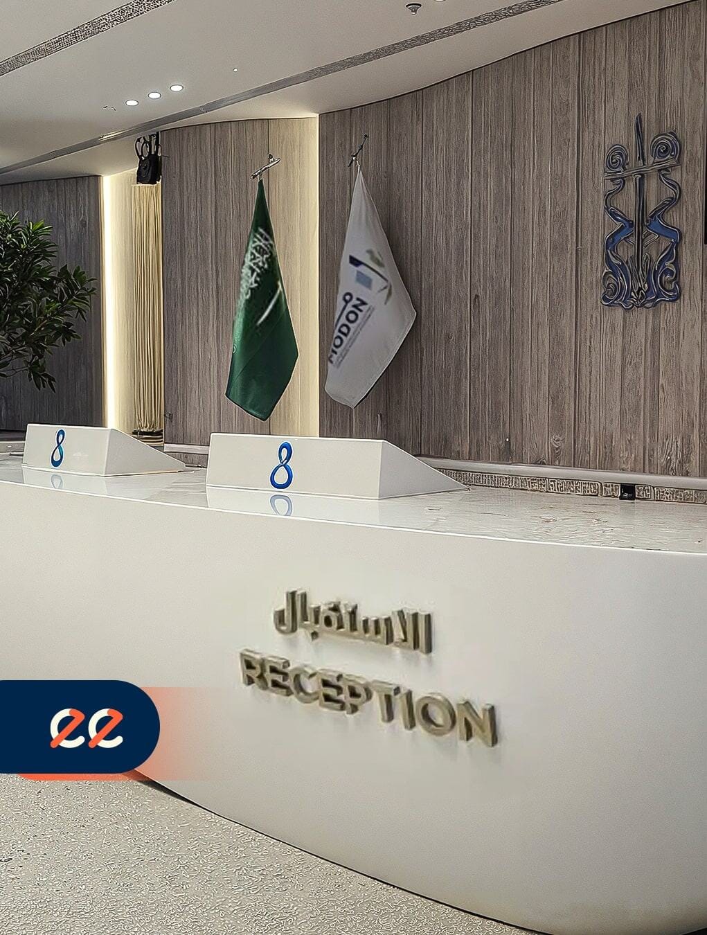 تصميم مشروع ايلفينز في منطقة الاستقبال مع علم المملكة العربية السعودية وشعار الشركة، يعكس احترافية وجودة عالية في مشاريعها المبتكرة.