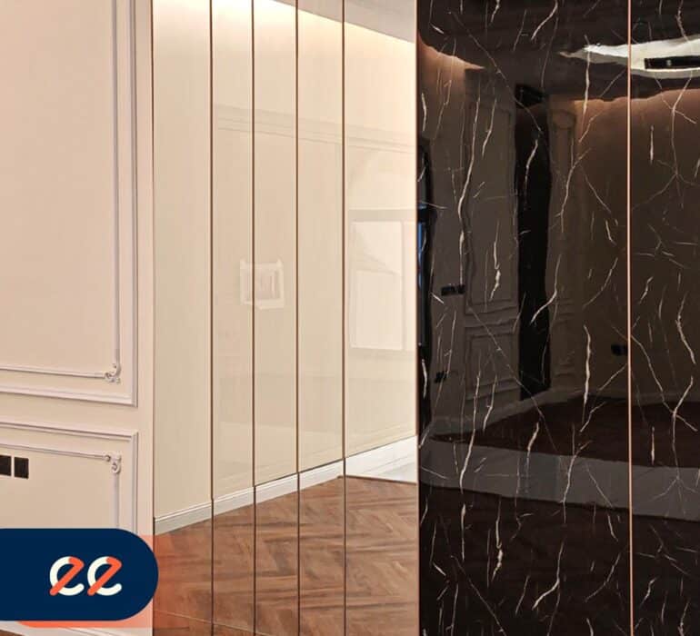 تصريح الصورة: مرآة فاخرة بتصميم أنيق وحديث تضيف لمسة من الفخامة والراحة للمساحات الداخلية، مع إطار ذهبي رفيع وواجهة سوداء مرقّعة بتدرجات مميزة، مثال على مشاريع إيلفينز.